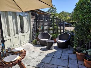 a patio with two chairs and a table and a table and chairs at Barn Owl in Happisburgh