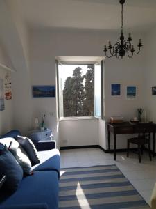 a living room with a blue couch and a window at Oltre Mare in Sori