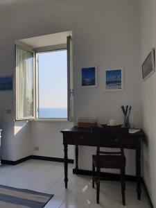 a piano in a room with a window and a chair at Oltre Mare in Sori