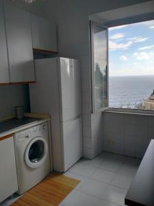 een keuken met een wasmachine en een raam bij Oltre Mare in Sori