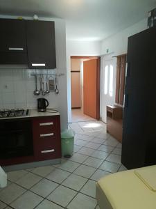 uma cozinha com armários castanhos e piso em azulejo em Apartment in Novi Vinodolski with Sea View, Terrace, Wifi, Washing Machine (3667-2) em Novi Vinodolski