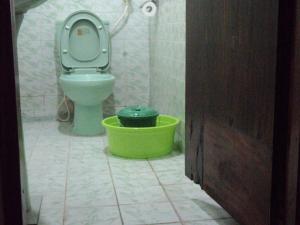 a bathroom with a toilet and a green bucket at SUPERFINE Apartment in Galle +55 photos