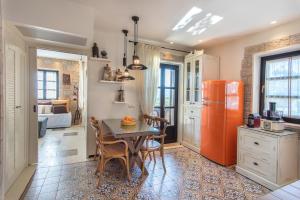 a kitchen with a table and a red refrigerator at Polismata - Private Residences in Kardamyli