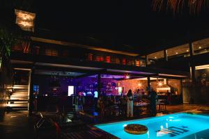 a night view of a bar and a pool at Che Bacalar Hostel & Bar Adults Only in Bacalar
