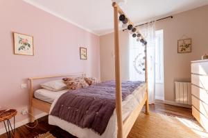 a bedroom with a canopy bed in a room at La Maison Rose in Grignan