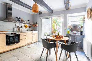 a kitchen with a wooden table and chairs at La Maison Rose in Grignan +30 photos