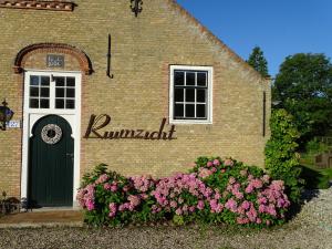 een bakstenen gebouw met bloemen ervoor bij B&B Hoeve Ruimzicht in Renesse