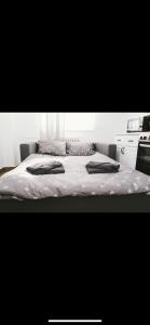 a bed with two pillows on it in a bedroom at Gloria Apartman in Požega