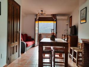 een woonkamer met een tafel en een bank bij Alojamiento Fuente La Caida in Arroyo Frio