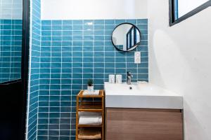 a bathroom with a sink and blue tiles at La Maison Rose in Grignan