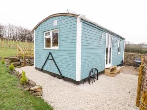 a blue tiny house in a garden at Robins Nest in Southam