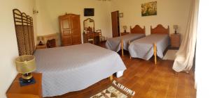 a bedroom with two beds and a wooden floor at Alojamento Local Céu-Azul in Porto de Mós