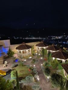 a view of a garden at night with lights at منتجع راحتي بيوت عطلات in Taif