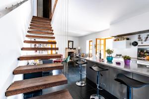 um bar com escadas de madeira num quarto com um balcão em La Maison de Catherine em Saint-Restitut
