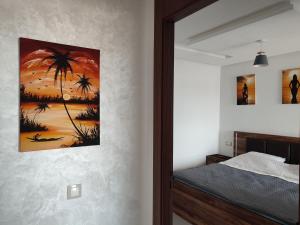 a bedroom with a bed and a painting on the wall at L'Orchidée de Kénitra in Kenitra