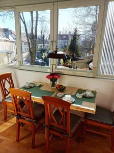 - une salle à manger avec une table, des chaises et des fenêtres dans l'établissement Galeria Helmut, à Peiting