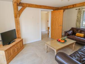 a living room with a couch and a television at Oak Cottage in Rochdale