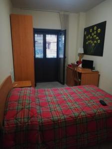a bedroom with a bed and a desk and a door at Raggio di Sole in Rende