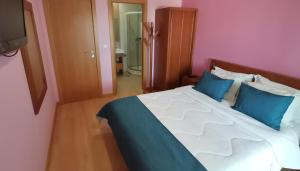 - une chambre avec un grand lit et des oreillers bleus dans l'établissement Hotel Hebe Peniche, à Peniche