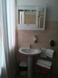 a bathroom with a sink and a mirror and a chair at Raggio di Sole in Rende +28 photos