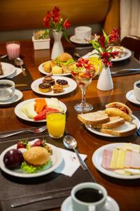 una mesa de madera con platos de comida. en Hotel Laghetto Siena Gramado, en Gramado