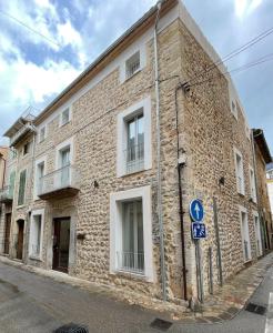 a brick building with white windows on a street at Meem Townhouse in Sóller