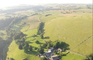 an aerial view of a farm in a field at Cruck Cottage in Buxton
