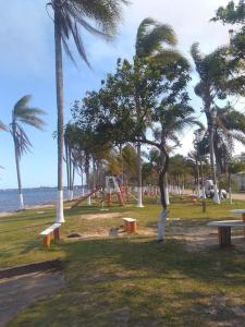 a park with benches and palm trees on the beach at Pousada Paraíso dos Accácio in Balneario Barra do Sul +42 photos