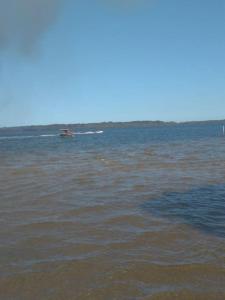 a boat in the middle of a large body of water at Pousada Paraíso dos Accácio in Balneario Barra do Sul