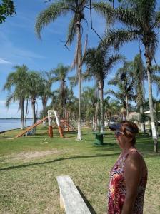 a woman standing next to a bench in a park at Paraíso dos Accácio in Balneario Barra do Sul