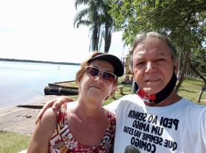 a man and a woman standing next to the water at Pousada Paraíso dos Accácio in Balneario Barra do Sul