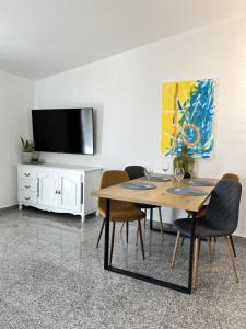 a dining room with a table and chairs and a tv at Apartment Lorun 47 in Tar