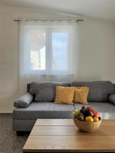 a living room with a couch and a bowl of fruit on a table at Apartment Lorun 47 in Tar