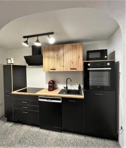 a kitchen with black appliances and wooden cabinets at Apartment Lorun 47 in Tar