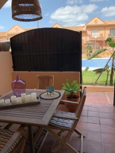 een houten tafel en stoelen op een patio bij Apartamento Residencial Al Andalus 117, La Barrosa, Chiclana, Incluye parking a unos metros del mar in Chiclana de la Frontera