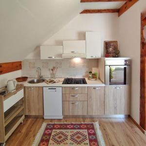 una cocina con armarios blancos y fregadero en Apartments Sanja, en Rakovica