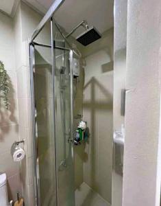 a shower with a glass door in a bathroom at Cozy 1BR with balcony at Fame Residences in Manila