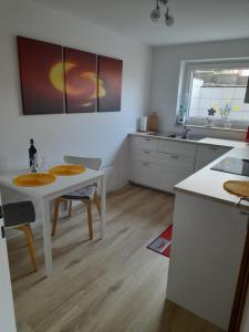 a kitchen with a white table and a sink at Ferienwohnung Heimathafen Westensee in Westensee