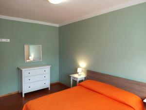 una camera con letto arancione e specchio di Casa Prati a Marina di Cecina