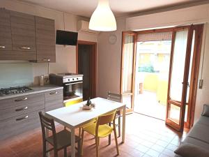Casa Prati في مارينا دي سيسينا: مطبخ مع طاولة وكراسي ومطبخ مع أريكة