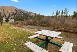 a picnic table sitting next to a river at Southfork Lodge Cabin 2 in Lowman