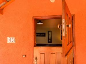Camera arancione con porta e specchio di Eco Resort Foz do Marinheiro a São João do Marinheiro