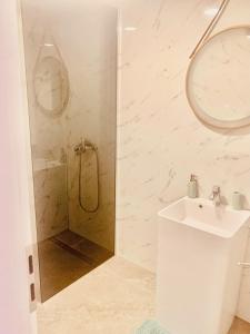 a white bathroom with a shower and a sink at Apartma FRIGO in Maribor