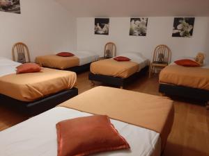 a room with four beds with red pillows at Chambres d hôtes LA FERME DES BOUTONS in Frizon-la-Haute