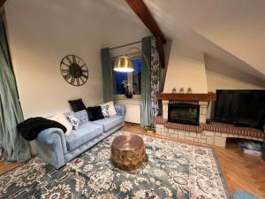 a living room with a blue couch and a fireplace at Comfort Zone Ostróda Villa Apartment C in Ostróda