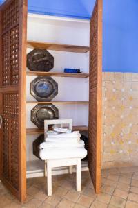 Zimmer mit einem Tisch und einem Regal mit Tellern in der Unterkunft Hotel Casa Miguel in Chefchaouen