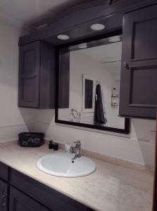 um balcão de casa de banho com um lavatório e um espelho em FLAMING 2 em Cullera