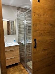 a bathroom with a glass shower and a sink at Casa Rural Chincha in Tragacete