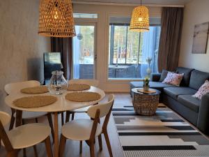 sala de estar con mesa, sillas y sofá en Kanervikko, en Kalajoki