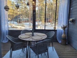 uma mesa e cadeiras num alpendre com uma janela em Kanervikko em Kalajoki